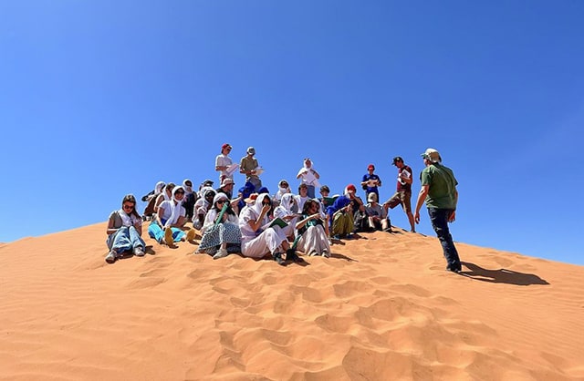 Students having a lesson on a sand dune